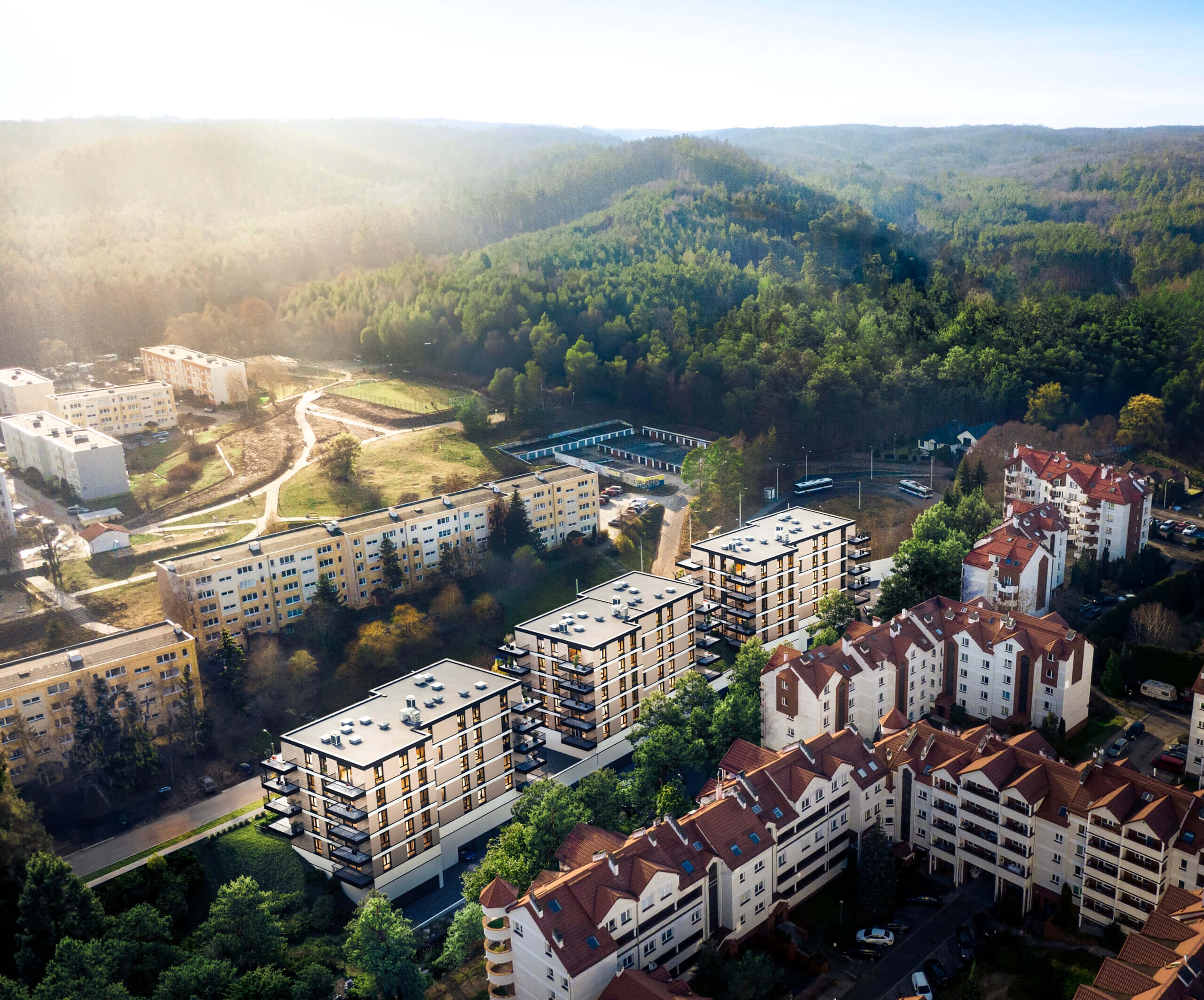 Widok z lotu ptaka na obszar podmiejski z nowoczesnymi budynkami apartamentowymi, otoczony bujnymi zielonymi lasami, w mglistym porannym słońcu.